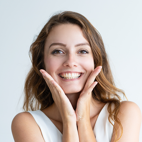 A happy smiling portrait of a young woman against a white background.