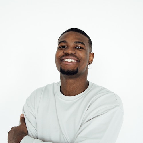 A happy smiling portrait of a man in front of a white background.